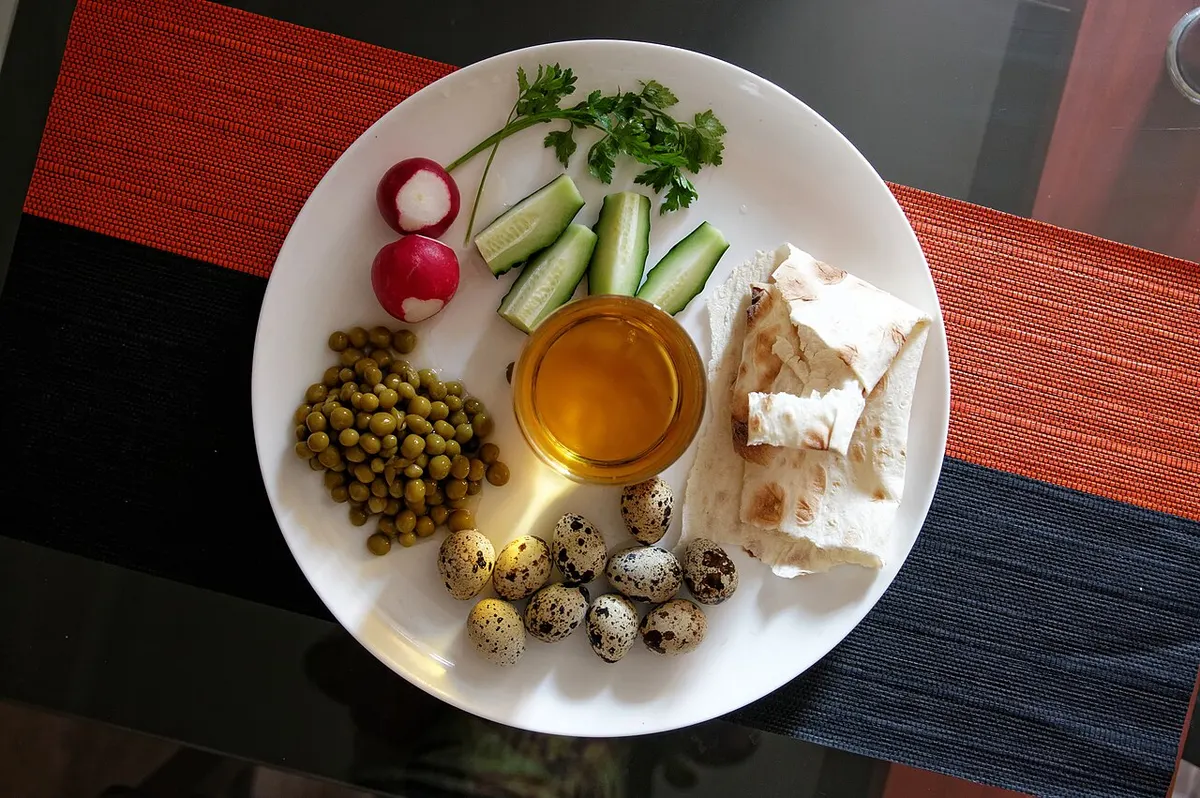 A plate of cooked quail eggs served with peas for breakfast